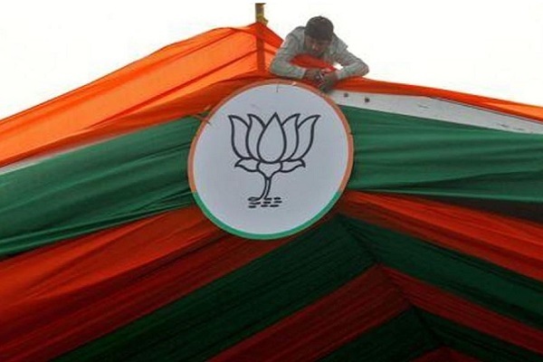 FILE PHOTO: A man installs the symbol of India's ruling Bharatiya Janata Party (BJP) on a tent during an election campaign rally by the party in Prayagraj, India, February 24, 2022. REUTERS/Ritesh Shukla