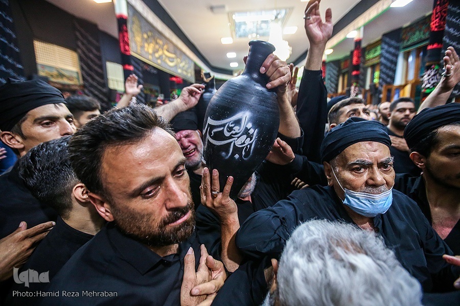 Mourners carry tubs and pots for Tasht-Gozari ritual in a mosque in Tehran in late July 2022.