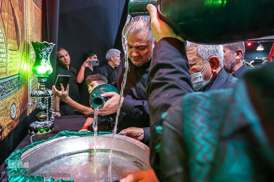 Mourners pour water into washtubs during Tasht-Gozari ritual in a mosque in Tehran in late July 2022.