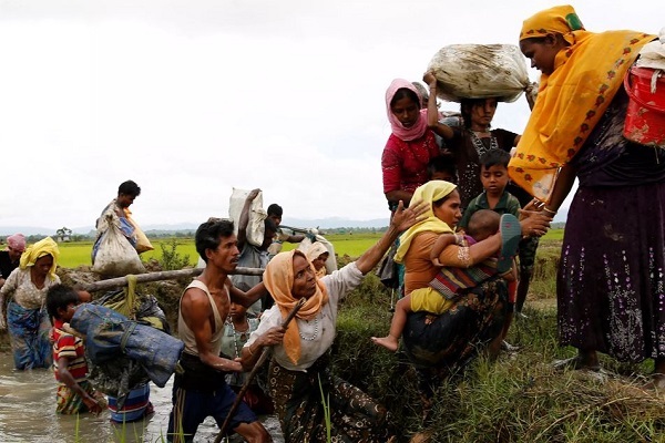 Rohingya refugees help each other after crossing the Bangladesh-Myanmar border