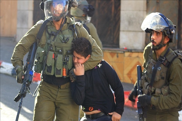 Israeli forces detaining a Palestinian boy