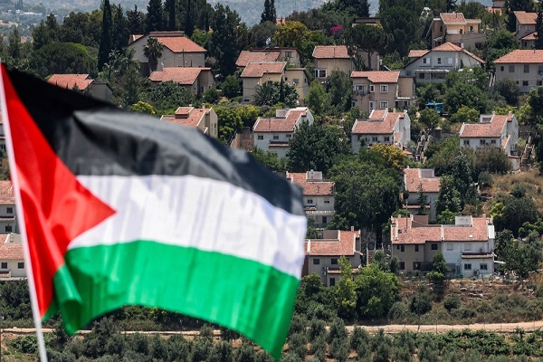 Israeli settlement of Halamish pictured behind a Palestinian flag raised in the village of Nabi Saleh, in the central part of the occupied West Bank