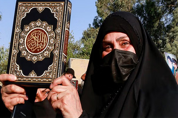 Muslim woman holding a copy of Quran in hands