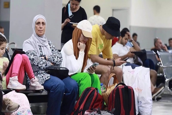Passengers sit in a waiting room on the Jordanian side of the King Hussein Bridge (also known as Allenby Bridge) between the West Bank and Jordan, on 19 July 2022