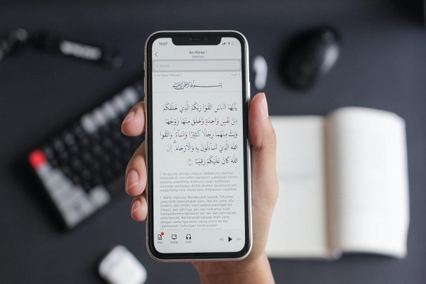 A Muslim using a Quranic app