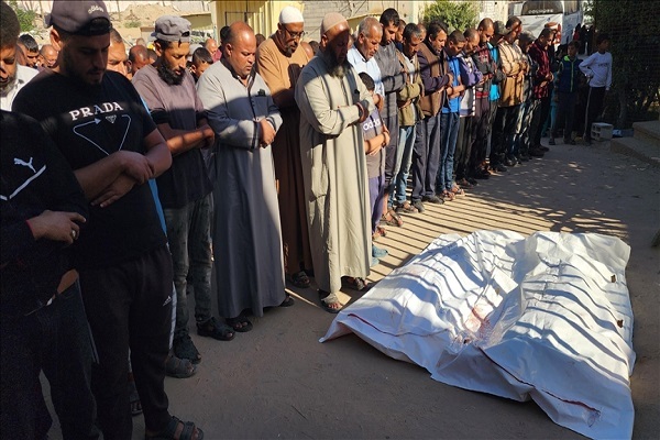 People performing funeral prayers for two individuals martyred in Israeli attacks on Gaza.