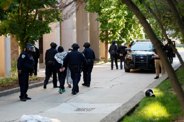 Three female pro-Palestinian protestors are detained by Wayne State University police after they protested the police raid of the campus encampment in Detroit, Michigan on May 30, 2024