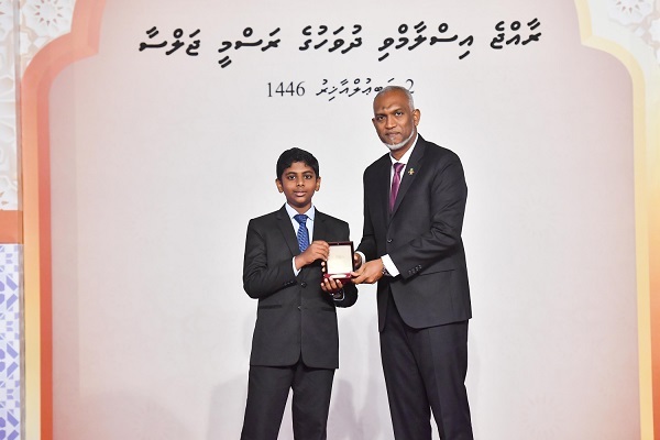 President of Maldives Mohamed Muizzu awarding a medal to a Quran memorizer