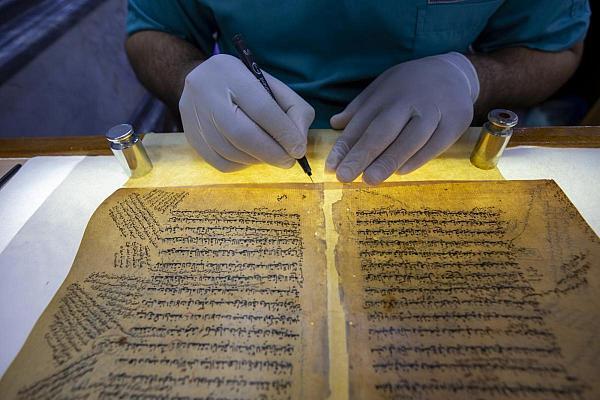 An expert restoring an old manuscript copy at Al-Fadl Center in Karbala, Iraq