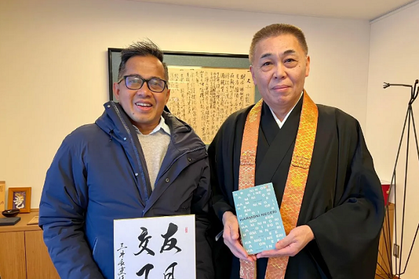 Miidera Temple's 164th Chief Priest Chori Geka Toshihiko Fuke (right) and Sakuranesia Founder Tovic Rustam exchange souvenirs during a visit to Miidera Temple (Onjoji) in Otsu, Shiga Prefecture, on Monday (12/23/2024).