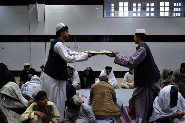 Afghan Muslims distribute food in a mosque during iftar on the first day of Islamic holy month of Ramadan in Kandahar on March 11, 2024