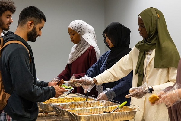 Sarah Jimenez, Miriam Matin and Ndumbeh Boye serve a variety of food, including macaroni and cheese and braised chicken, to students during Ramadan in Chapel Hill, N.C., on Monday, April 3, 2023.