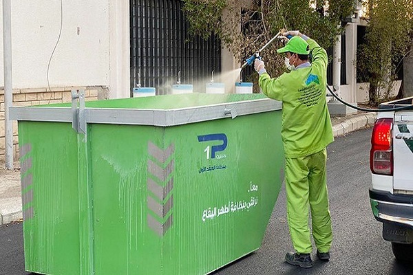 A cleaner sanitizing a waste container in Mecca