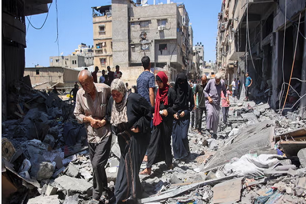 People walk through the rubble of destroyed buildings in al-Shati in Gaza City on Saturday.