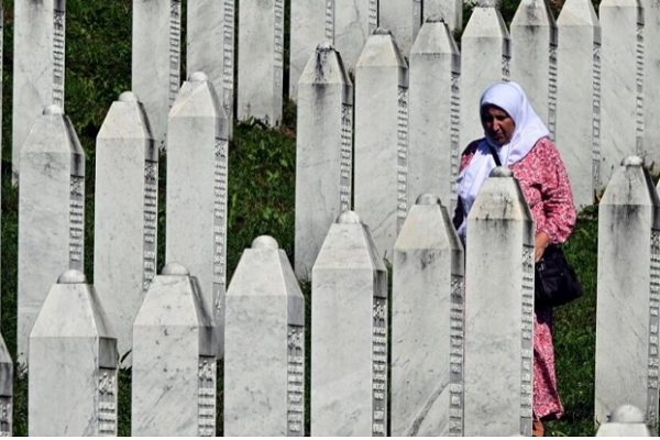 A Bosnian Muslim survivor of the 1995 Srebrenica genocide walks among headstones as she visits the graves of her relatives at the memorial cemetery in Potocari, near the eastern Bosnian town of Srebrenica, July 11, 2024.