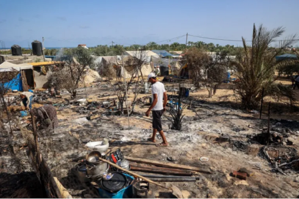 Palestinians look for salvageable data-x-items from the remains of tents burned down by an Israeli raid in the al-Mawasi area, northwest of the city of Rafah on June 29, 2024