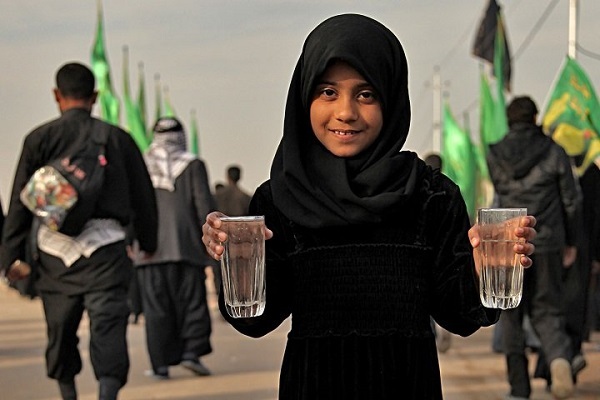 An Iraqi girl serving water to Arbaeen pilgrims