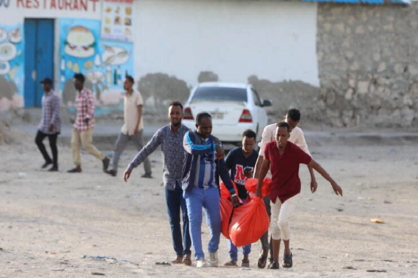 Relatives carry the body of a woman killed during an attack in Mogadishu on August 3, 2024.