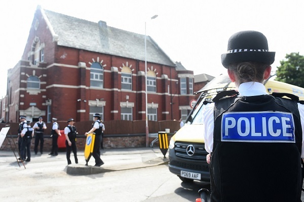 Police officers stand guard outside the Southport Islamic Society Mosque in Southport, northwest England, on 31 July 2024 (AFP/Peter Powell)