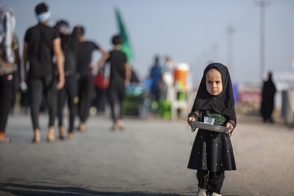 An Iraqi girl serving water to Arbaeen pilgrims