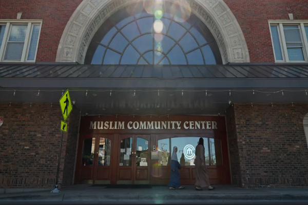 A woman and child walk past the Muslim Community Center, 4380 N. Elston Ave., Saturday, Sept. 7, 2024, in Chicago. Glass on an entry door of the center was vandalized earlier in the week.