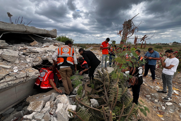 Palestinian civil defense workers collect human remains in the Netzarim corridor in central Gaza.