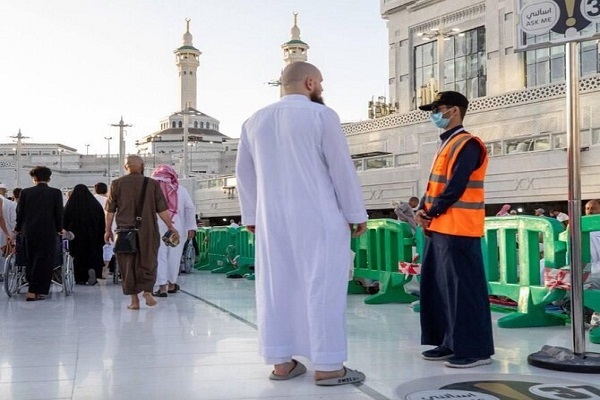 A volunteer guides assists a pilgrim at the Grand Mosque in Mecca