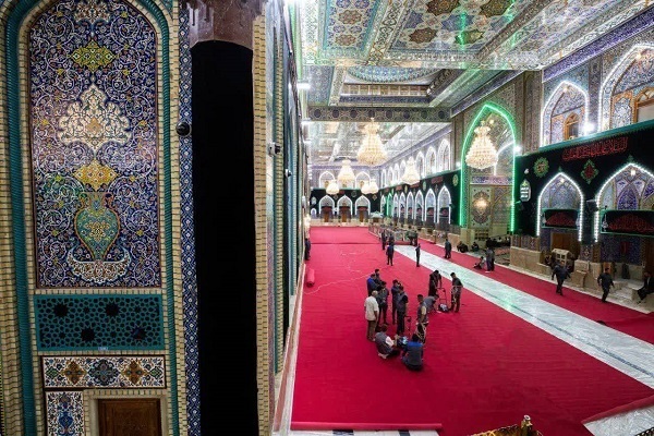 Servants cover the floors of the holy shrine of Imam Hussein (AS) in Karbala, Iraq, with red carpets.