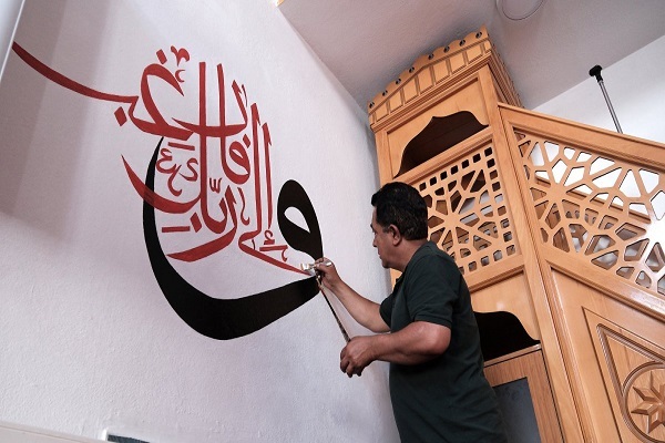 Turkish calligrapher Emin Deniz decorating the wall of a mosque in Van, Eastern Turkey, with a verse from the Holy Quran.