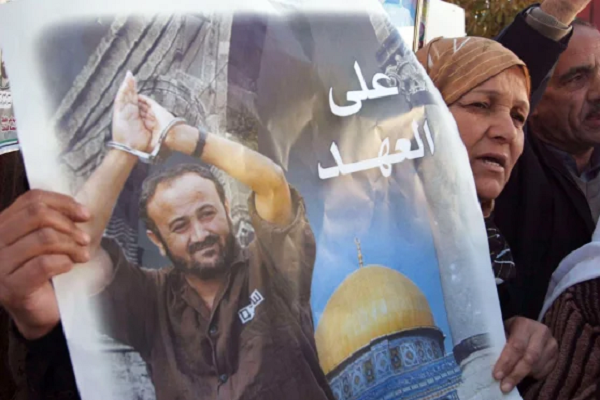 A woman raising a photo of jailed Palestinian leader Marwan Barghouti