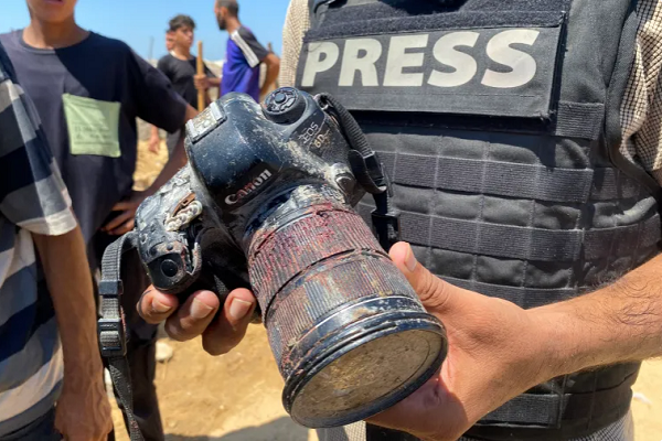 A journalist holds the blood-covered camera belonging to Palestinian journalist Mariam Abu Daqqa, who was killed in an Israeli strike on Nasser Hospital in Khan Younis, in the southern Gaza Strip, during her funeral on Monday, August 25, 2025.
