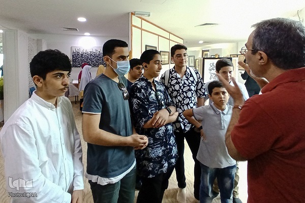 پیمان پیروی در حال شرح تابلوهای هنری خود به دانش‌آموزان ایرانی مقیم مالزی