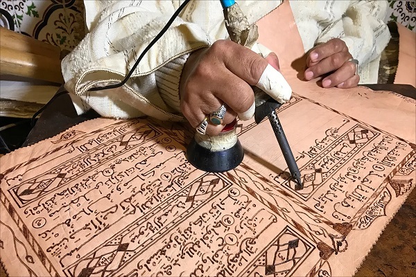 خلاقیت هنرمند معلول مراکشی در کتابت قرآن بر روی پوست بز