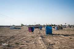 تقریبا 200 خانواده در اردوگاه بحره در دیر‌الزور زندگی می‌کنند؛ در آنجا شرایط بهداشتی بسیار وخیم است. پرده آبی یک دستشویی عمومی را پوشانده است.
