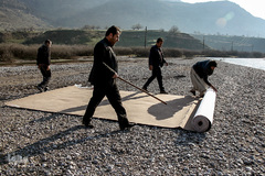 ماموران کمیته امداد امام خمینی(ره) به همراه یکی از اهالی روستا موکتی که برای مردم آورده‌اند را متر می‌زنند. مردم در این منطقه از کمترین و ساده ترین امکانات مانند آب لوله کشی و برق بی‌بهره‌اند.
