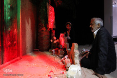 وی در حال توضیح دادن ماکت خانه حضرت زهرا(س) به نوه‌اش ساجده است.