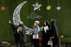 زنان عراقی در حال سلفی گرفتن با نقش هلال ماه رمضان روی دیوارهای شهر نجف 