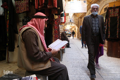یک شهروند فلسطینی ساکن شهر قدیمی هبرون، در جنوب کرانه باختری، هنگام انتظار برای دریافت صبحانه، قرآن کریم را می خواند.