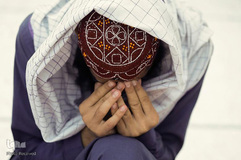 مردی که کف دستهای خود را به دست گرفته، قبل از افطار در مسجدی در پیشاور پاکستان نماز می خواند