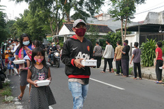 اندونزیایی ها برای دریافت صبحانه های رایگان که توسط یک خیریه در منطقه سمباکا پوته جاکارتا توزیع می شود در صف ایستاده اند.